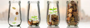 Glass jars with coins, showing money growing