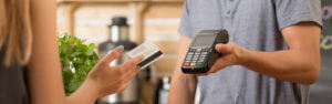 Woman paying with her debit card and a shop employee with a card reader