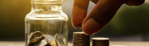 A jar with coins that someone is counting