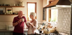 Older couple drinking coffee in kitchen
