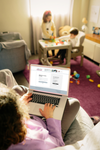 Woman on laptop in children's room