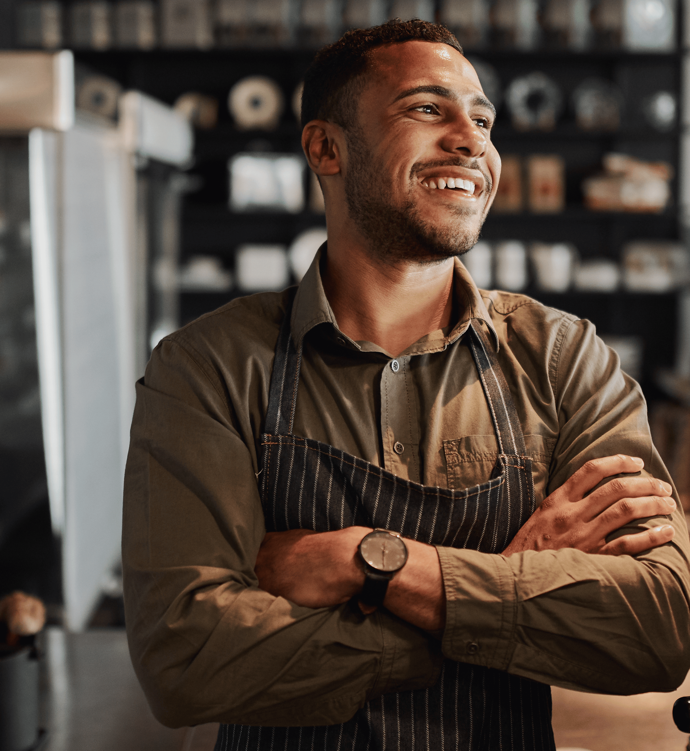 Man with arms folded smiling in his business