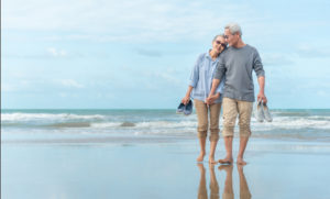 Senior Couple walking down beach together