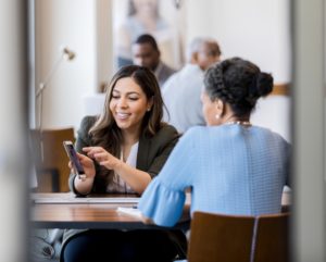 Cheerful bank employee shows customer banking app