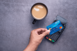 Person paying for coffee with contactless card payment