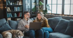 Mature couple at home using video call to talk with friends or family during pandemic isolation period.