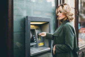 Young woman using ATM