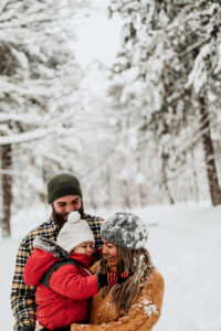 Happy family on vacation, walking in snowy forest