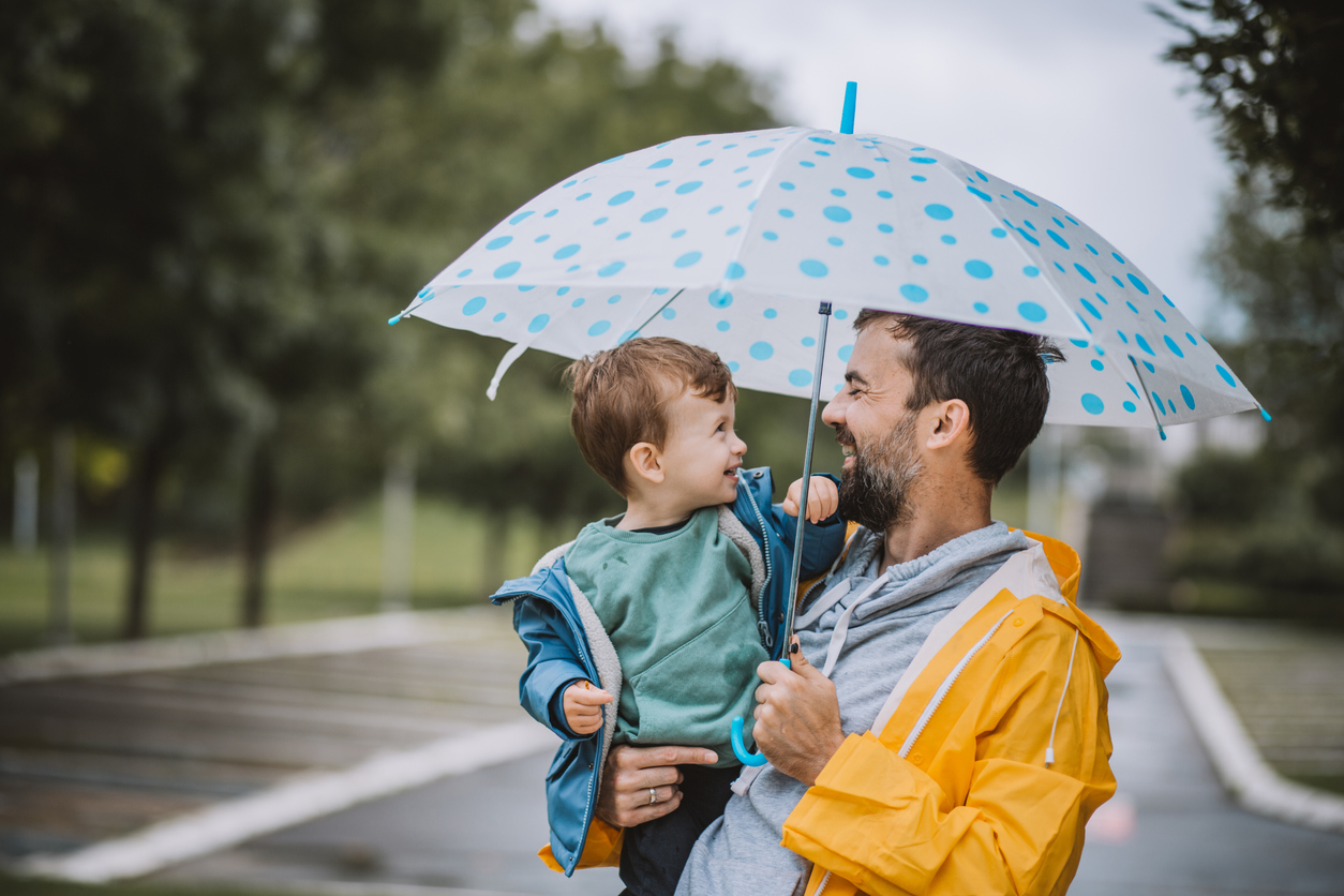 Father and son having fun on rainy day.