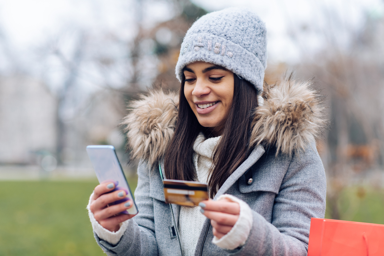 Young woman shopping online outdoors