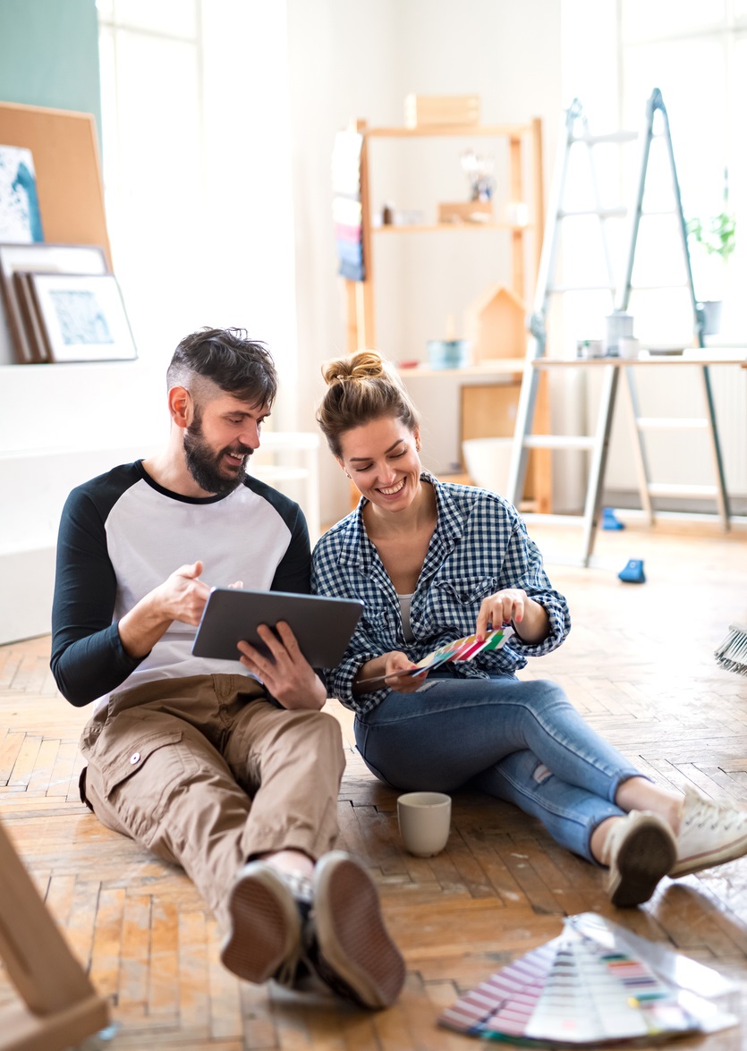 Front view of mid adults couple planning with tablet indoors at home, relocation and diy concept.