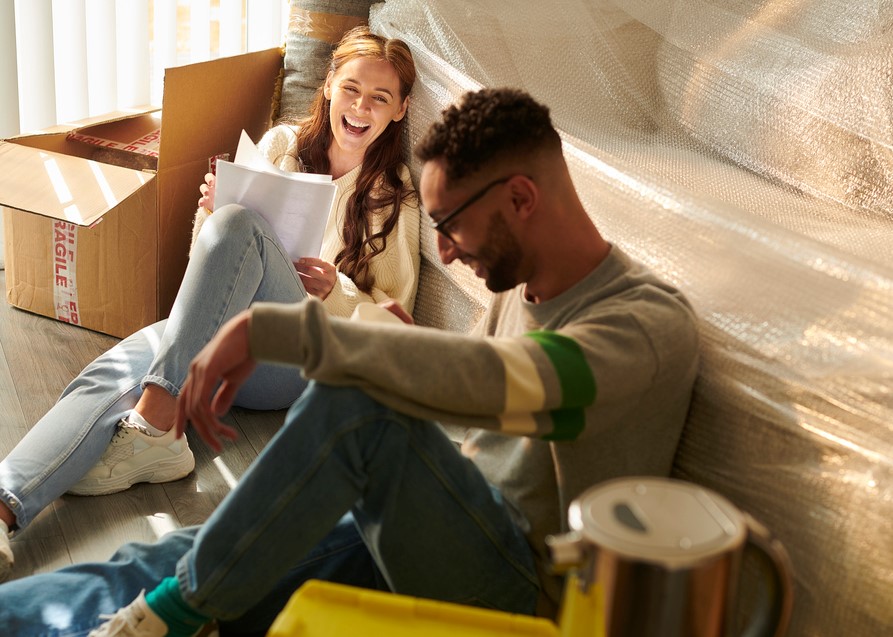young couple take a break from moving in and check their contract