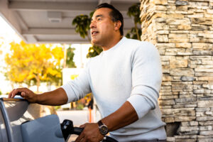 Mature Hispanic man filling gas tank