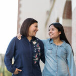 Latin Mother And Teenage Daughter Smiling Together