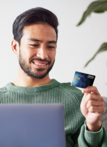 Man making a purchase on laptop with credit card.