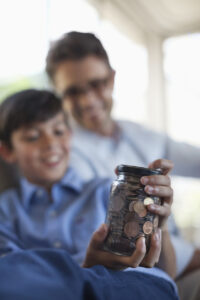 Father And Son Holding Change Jar