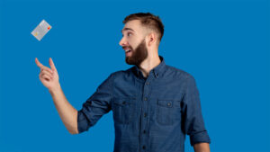 Smiling man catching a credit card falling into his hand