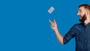 Smiling man catching a credit card falling into his hand