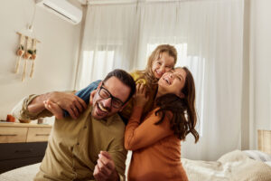 Young Cheerful Family Having Fun In Bedroom.