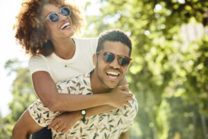 Playful Man Giving Piggyback Ride To Woman
