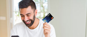 Man using credit card to pay online with smartphone