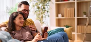 Couple using the phone on their couch