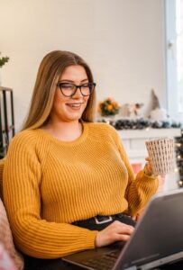Woman at home using laptop and drink tea