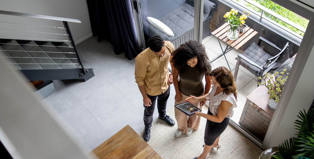 Overhead shot of a couple with a consultant in their home.