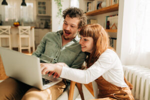 Happy couple looking at laptop