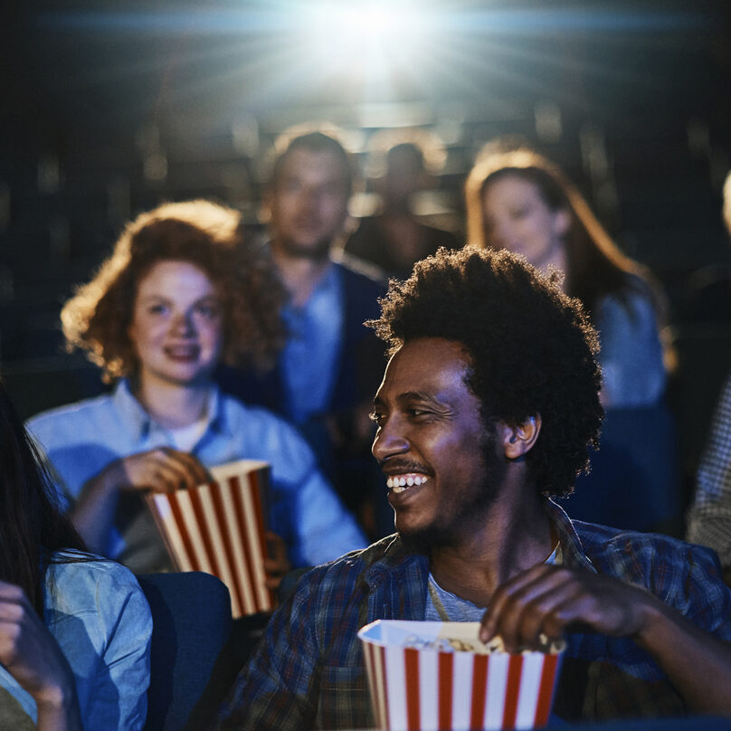 Close up of a group of friends enjoying a movie in the cinema
