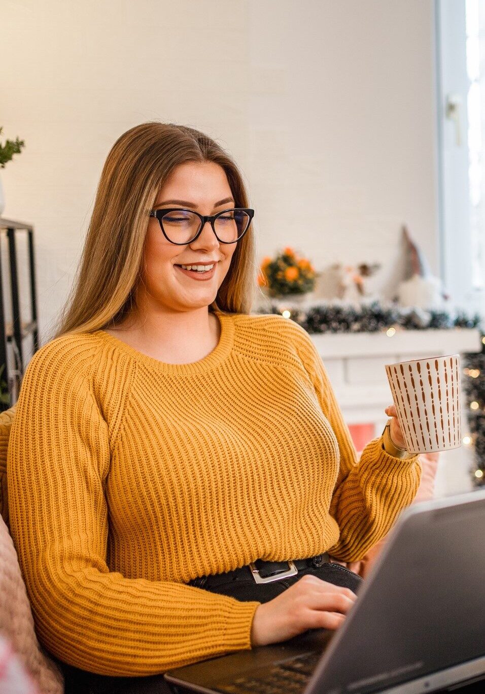 Woman at home using laptop and drink tea