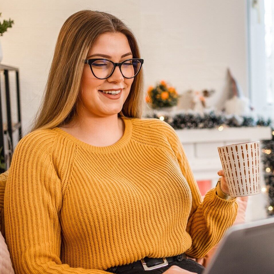 Woman at home using laptop and drink tea